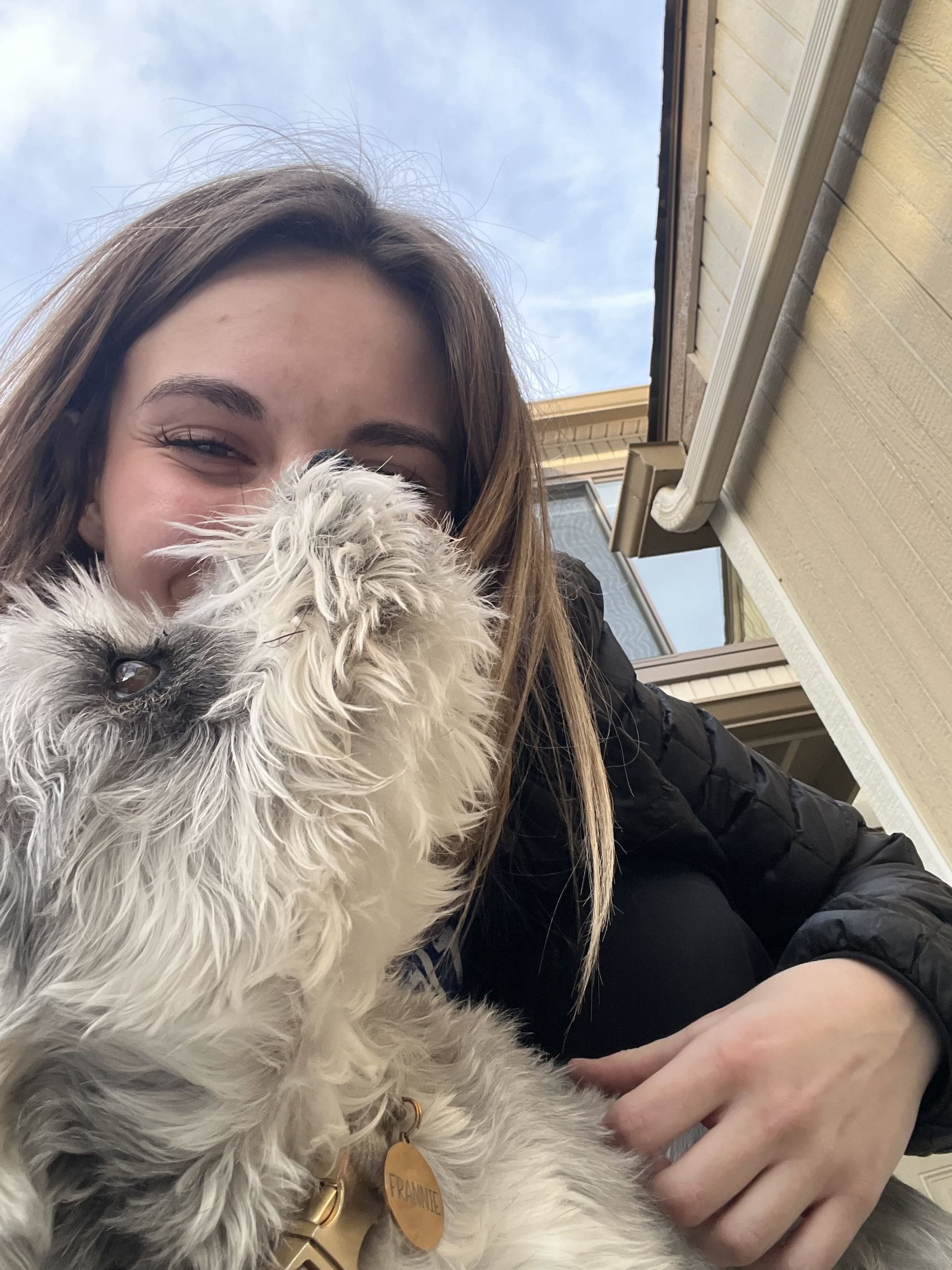 Samantha outdoors holding a small fluffy dog
