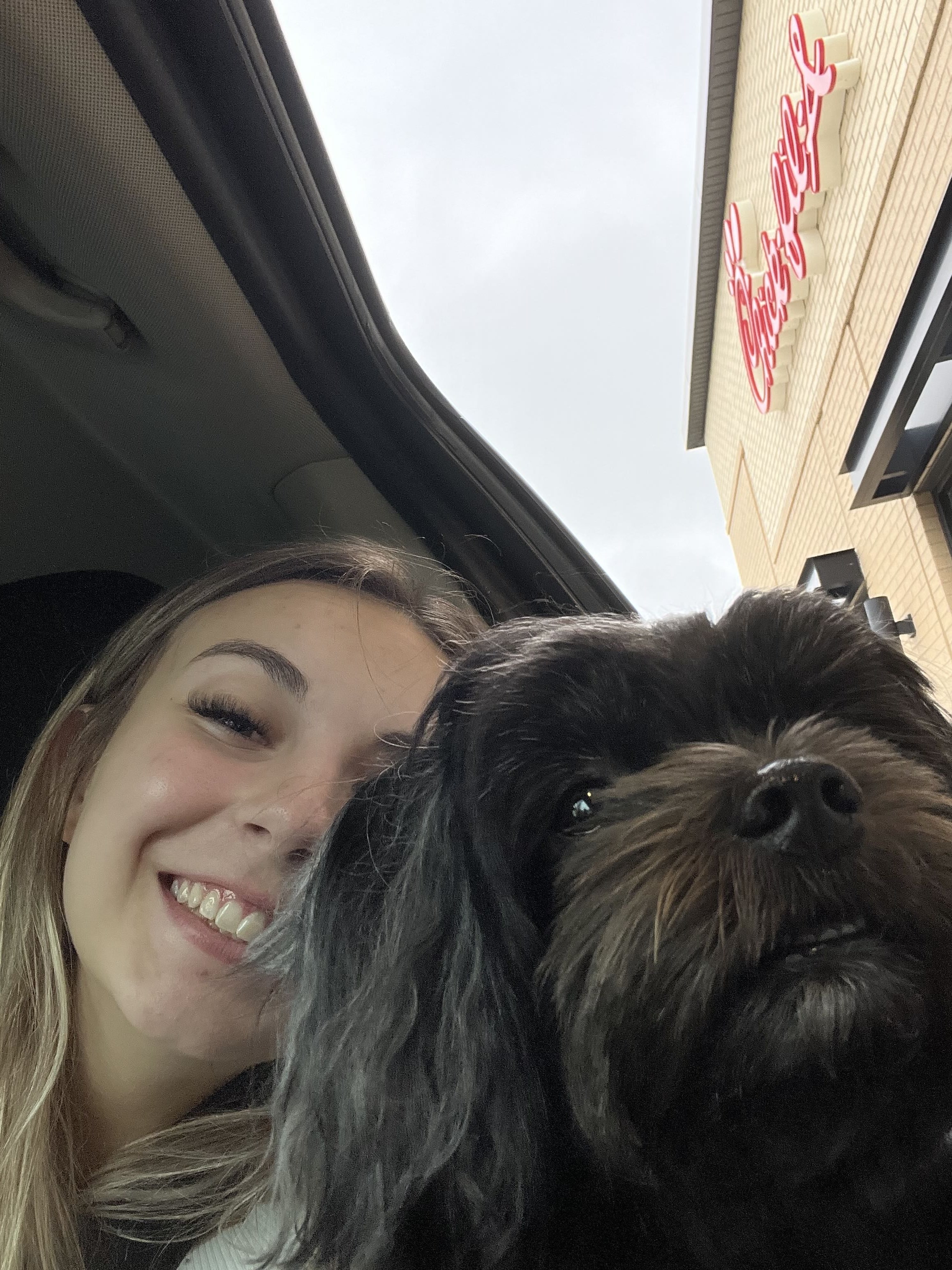 Samantha in car with a small dark-colored dog